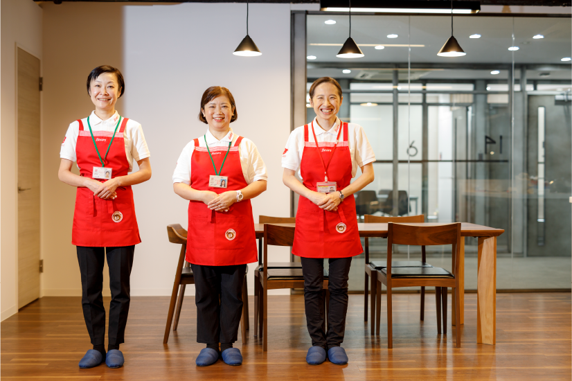 赤いエプロン姿の家事代行スタッフ3人