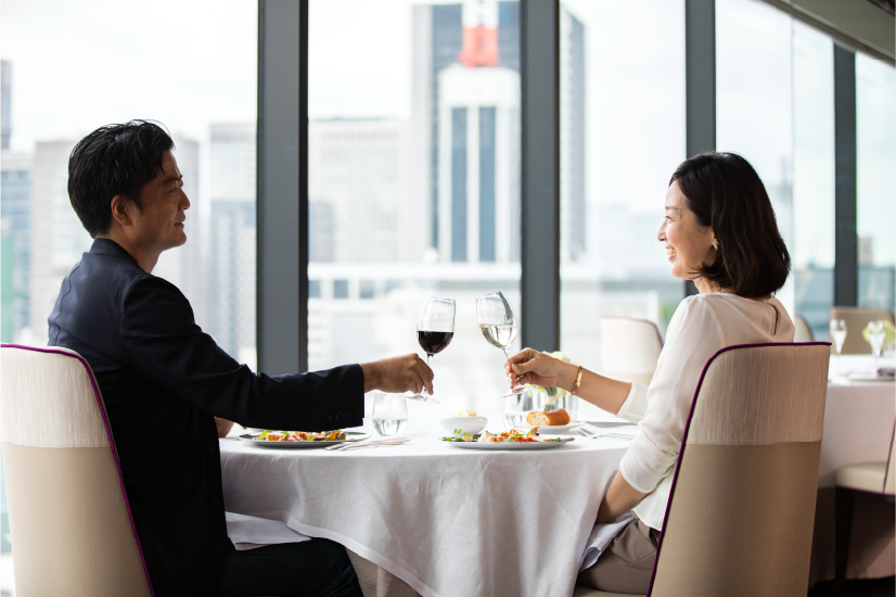 レストランで食事をしながら乾杯する2人